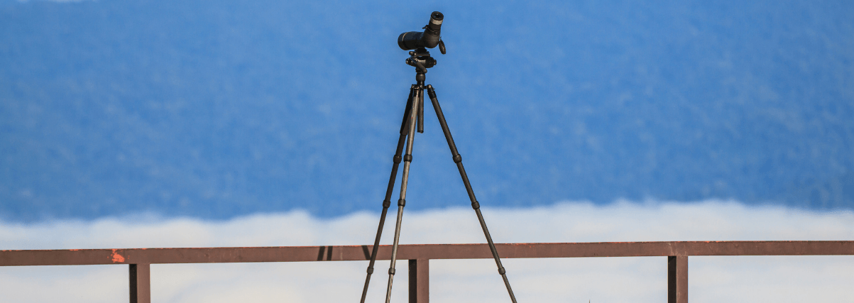 A spotting scope on a tripod - outdoors.